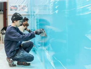 Young artists working on a light blue wall